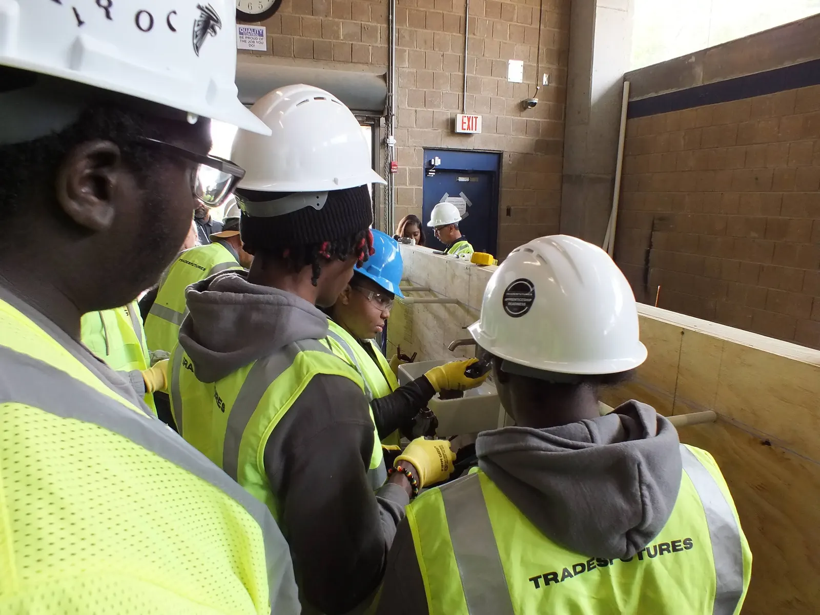 TradesFutures participants in hi-vis vests working at a bench